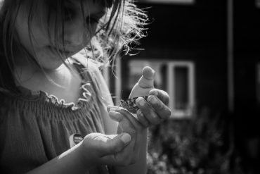 child holding butterfly by elora viano